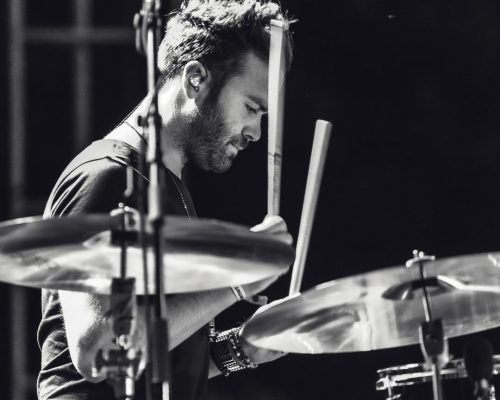 Man is playing drums. Black and white picture.